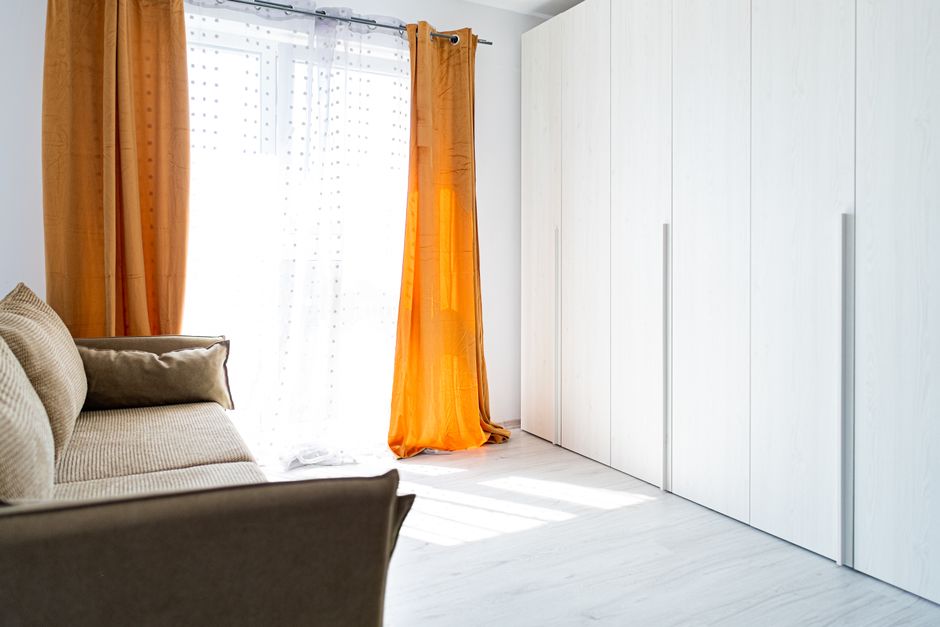 Warme oranje gordijnen met houten meubels.